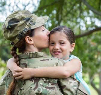Woman in uniform smiling with little girl