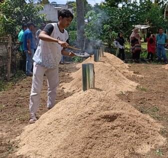 worker converting rice husks to biochar